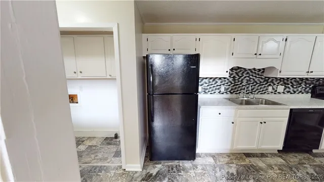 a kitchen with white cabinets and refrigerator