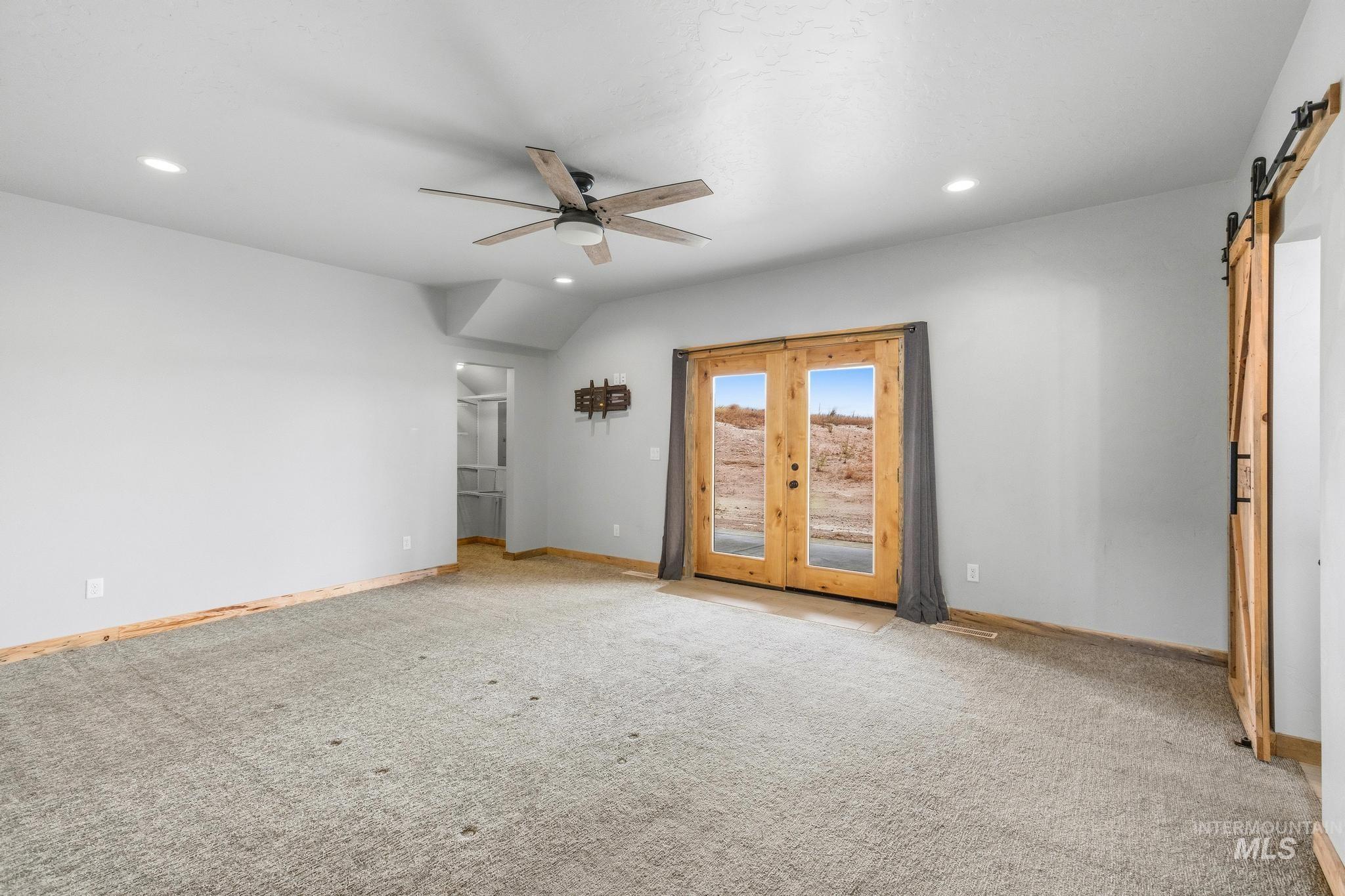 870 Desert Wind Road Boise, ID 83716 - Photo 16 of 50 Spacious living area featuring a floor-to-ceiling stone fireplace, soaring ceilings, and natural wood-finish flooring