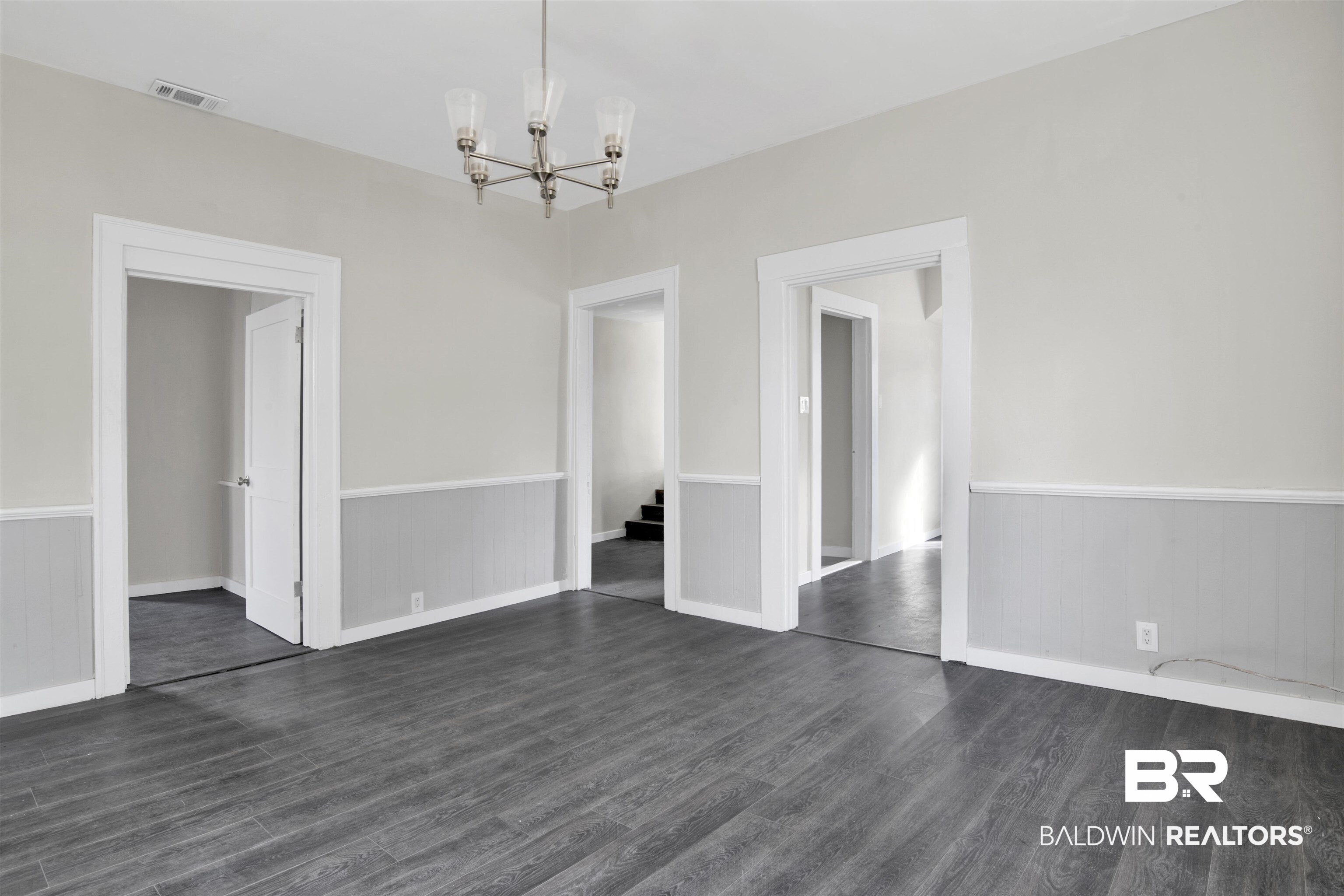 1063 Selma Street Mobile, AL 36604 - Photo 11 of 32 Unfurnished dining area with wainscoting, hanging lights, and dark wood-style floors