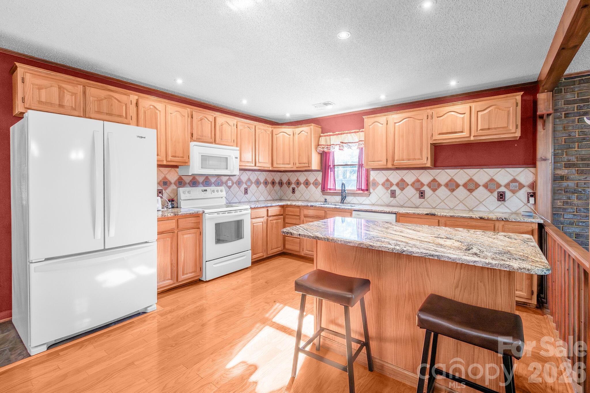 1295 Cattle Ridge Road Cheraw, SC 29520 - Photo 9 of 21 a kitchen with stainless steel appliances granite countertop a refrigerator a sink dishwasher a stove with white cabinets and wooden floor