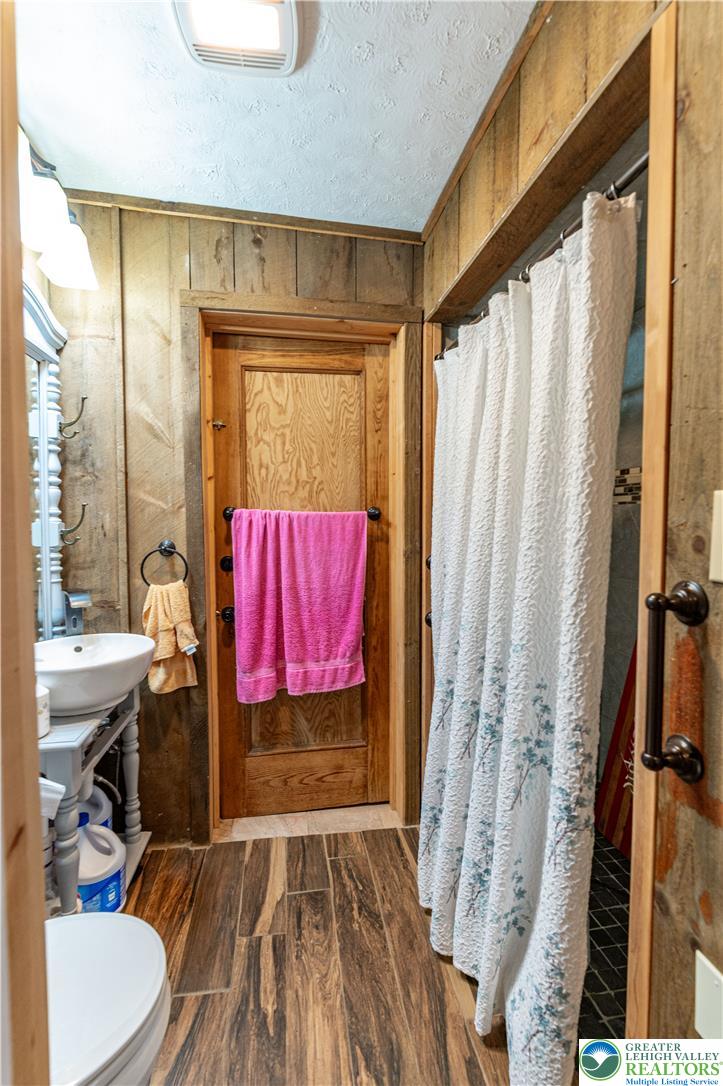 2485 Hieter Road Quakertown, PA 18951 - Photo 11 of 97 Natural wood paneling complements the richly toned wood-look flooring in this rustic bath space.