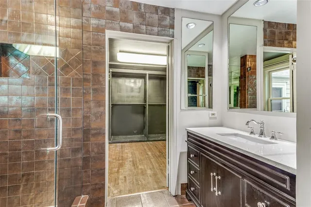 a bathroom with a sink a mirror and a shower