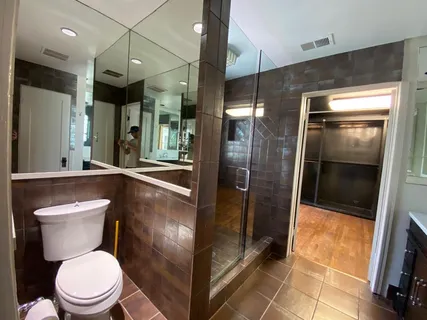a bathroom with a toilet a sink and glass door shower