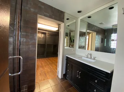 a bathroom with a double vanity sink a mirror and shower