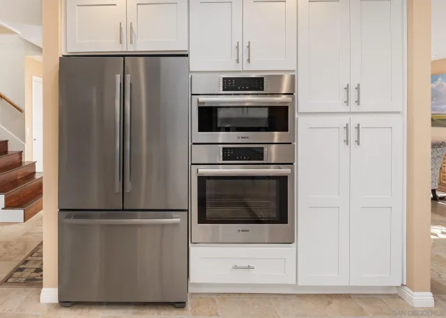 a room with kitchen island granite countertop a sink cabinets and window