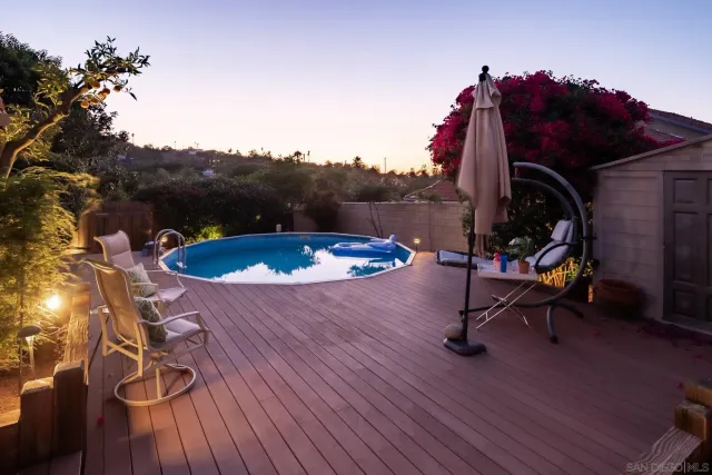 a view of backyard with wooden fence and large trees