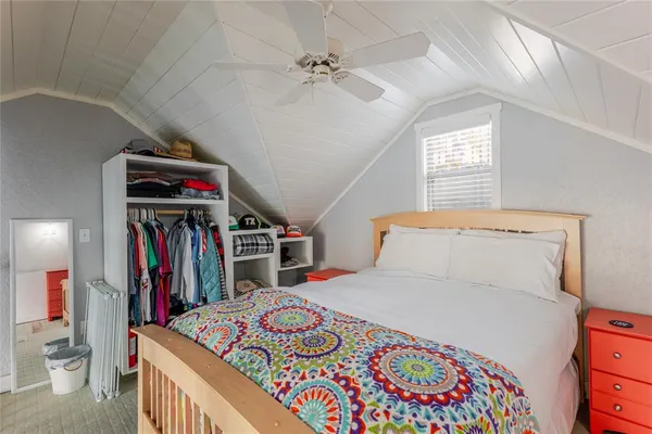 a bedroom with a large bed and a book shelf