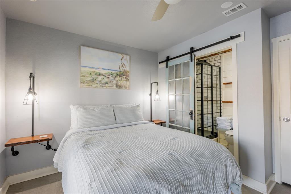 3005 Upcreek Alley, Unit 4 Strawn, TX 76475 - Photo 7 of 29 a bedroom with a large bed and a chandelier