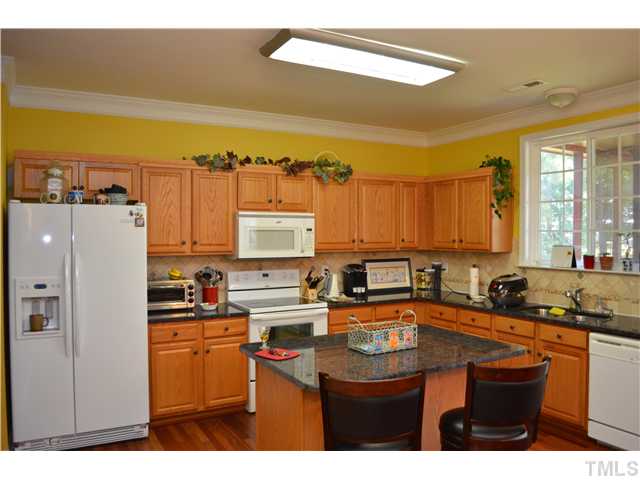 5853 Parkchester Road Raleigh, NC 27616 - Photo 3 of 19 a kitchen with stainless steel appliances a sink a stove a refrigerator cabinets and a counter top space