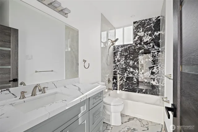 a bathroom with a bathtub sink vanity and toilet