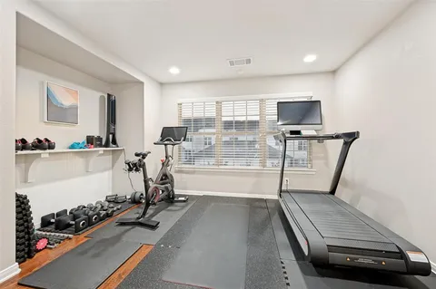a room with furniture gym equipment and a large window