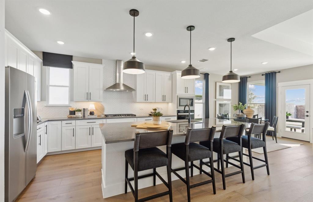 11129 Carham Street Haslet, TX 76052 - Photo 4 of 19 a kitchen with stainless steel appliances kitchen island granite countertop a table chairs and a refrigerator