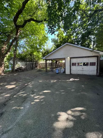 a front view of a house with a garden and tree