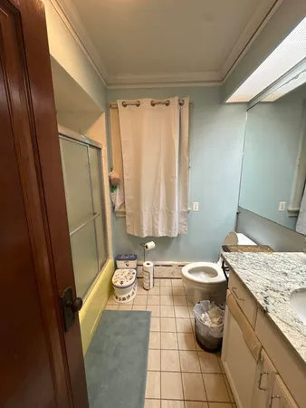 a bathroom with a granite countertop sink toilet and shower