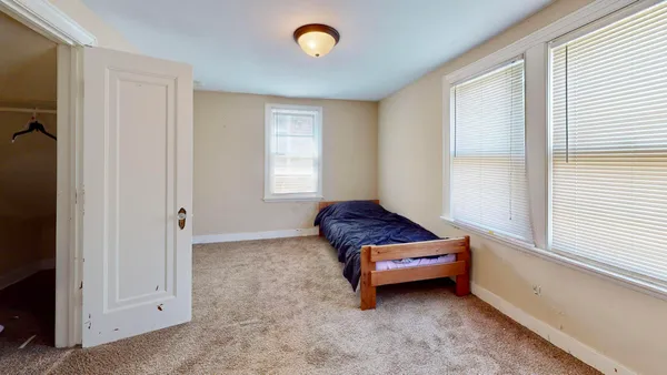 an empty room with windows and cabinet