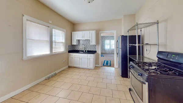 a kitchen with granite countertop white cabinets and stainless steel appliances