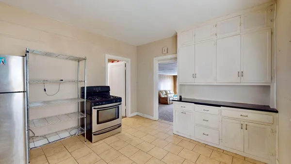 a kitchen with granite countertop white cabinets and stainless steel appliances
