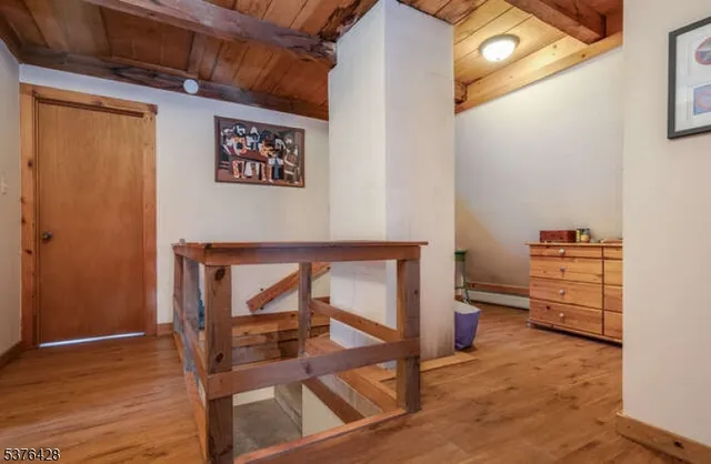 a view of a hallway with wooden floor and furniture