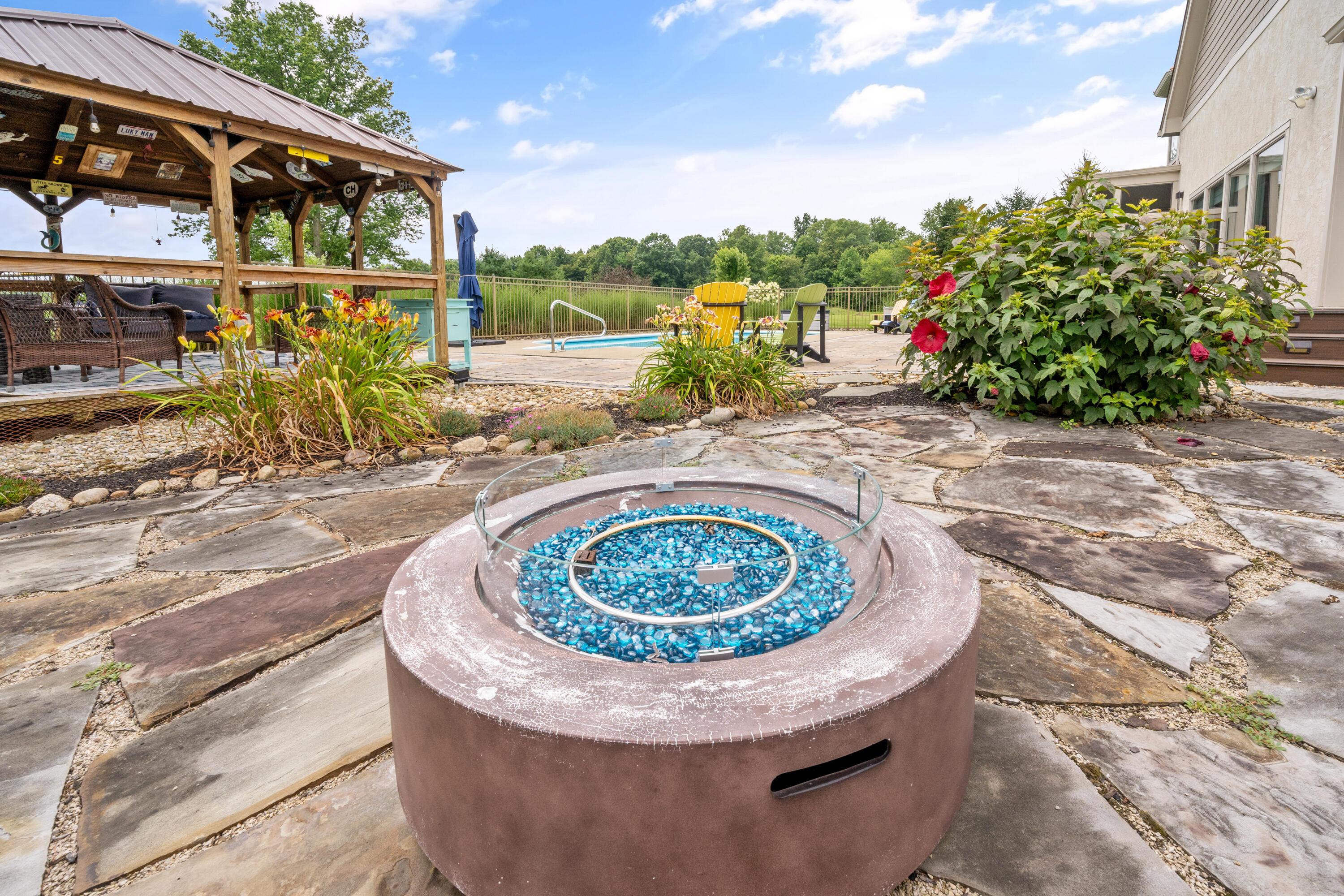 4640 Maynard Road Delaware, OH 43015 - Photo 65 of 91 Outdoor fire pit with blue glass, surrounded by an expansive flagstone patio