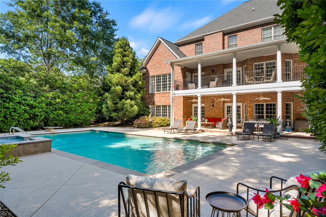 200 Graylyn Drive Anderson, SC 29621 - Photo 43 of 48 A spacious outdoor oasis features a refreshing pool and spa, complementing the grand brick structure with multiple levels of balconies and covered patios.