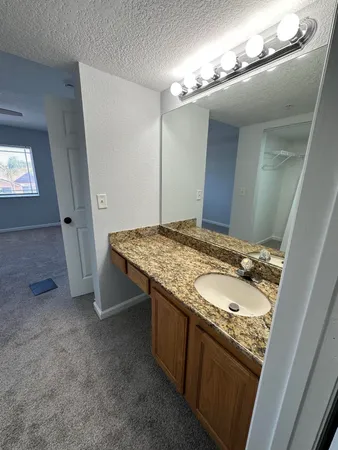 a bathroom with a granite countertop sink and a mirror
