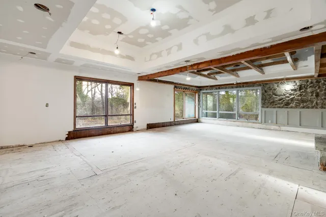 a view of an empty room with a windows and a ceiling fan