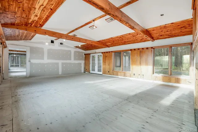 a view of an empty room with a fireplace and windows