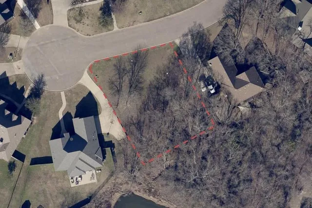 an aerial view of a house with a yard and large tree