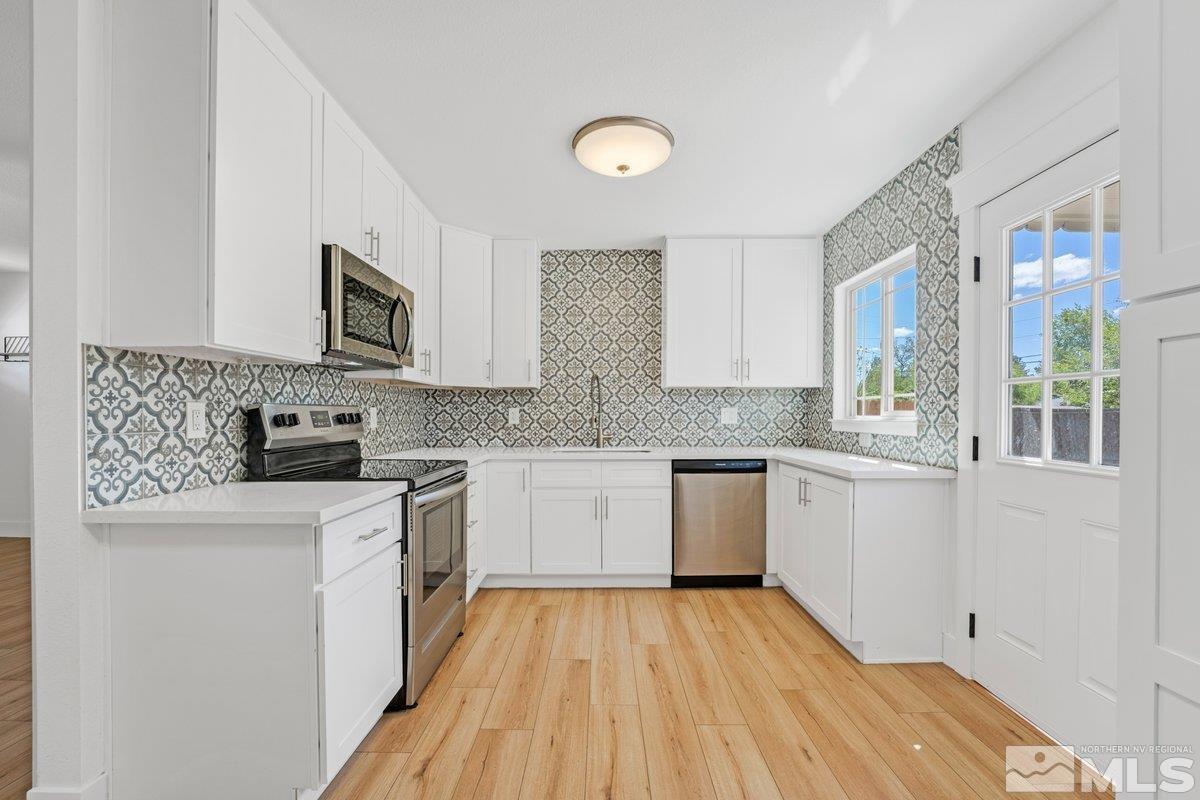 441 I Street Sparks, NV 89431 - Photo 4 of 16 a kitchen with granite countertop a sink cabinets stainless steel appliances and a counter space