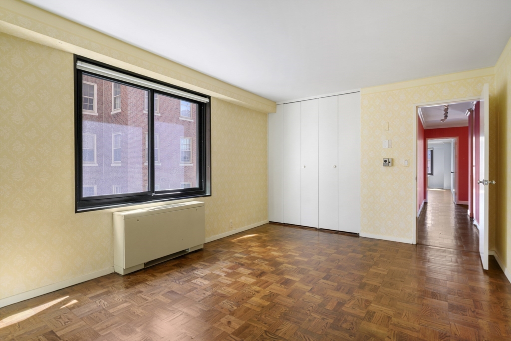 180 Beacon Street, Unit 6A Boston, MA 02116 - Photo 19 of 26 a view of an empty room with wooden floor and a window