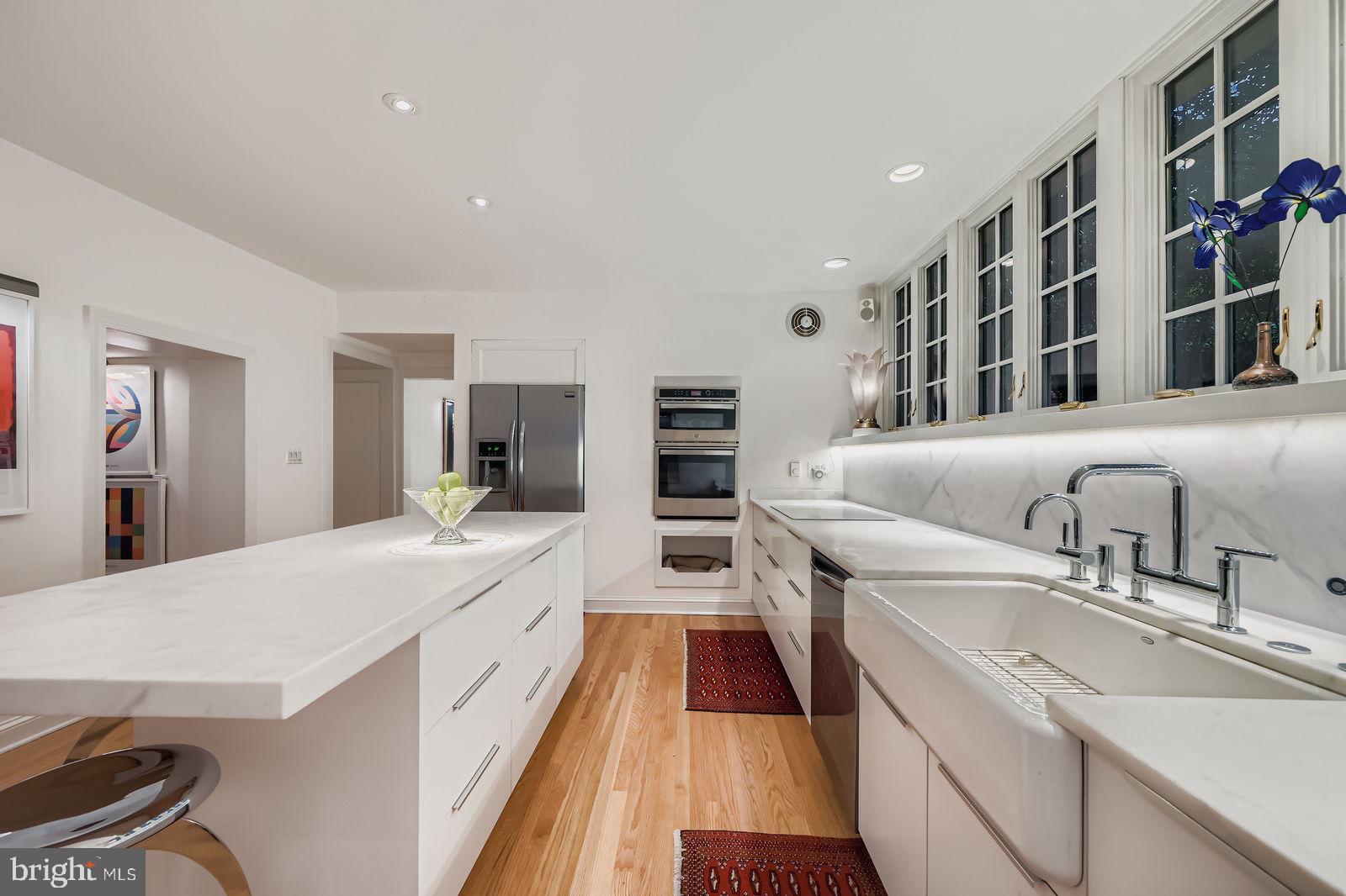 2436 Pickwick Road Baltimore, MD 21207 - Photo 11 of 66 a large white kitchen with stainless steel appliances