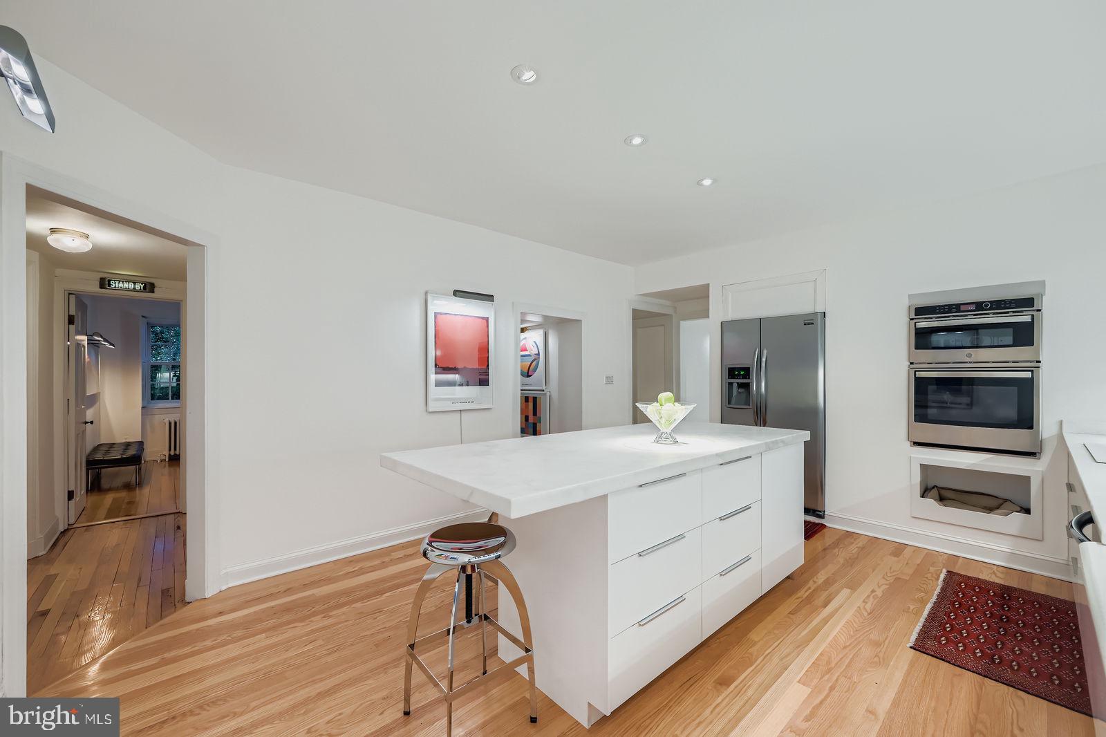 2436 Pickwick Road Baltimore, MD 21207 - Photo 10 of 66 a hall with kitchen island white cabinets and stainless steel appliances