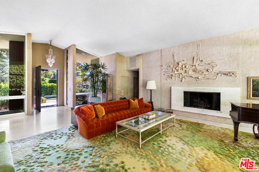 1005 Summit Drive Beverly Hills, CA 90210 - Photo 11 of 48 a living room with furniture a rug and a fireplace