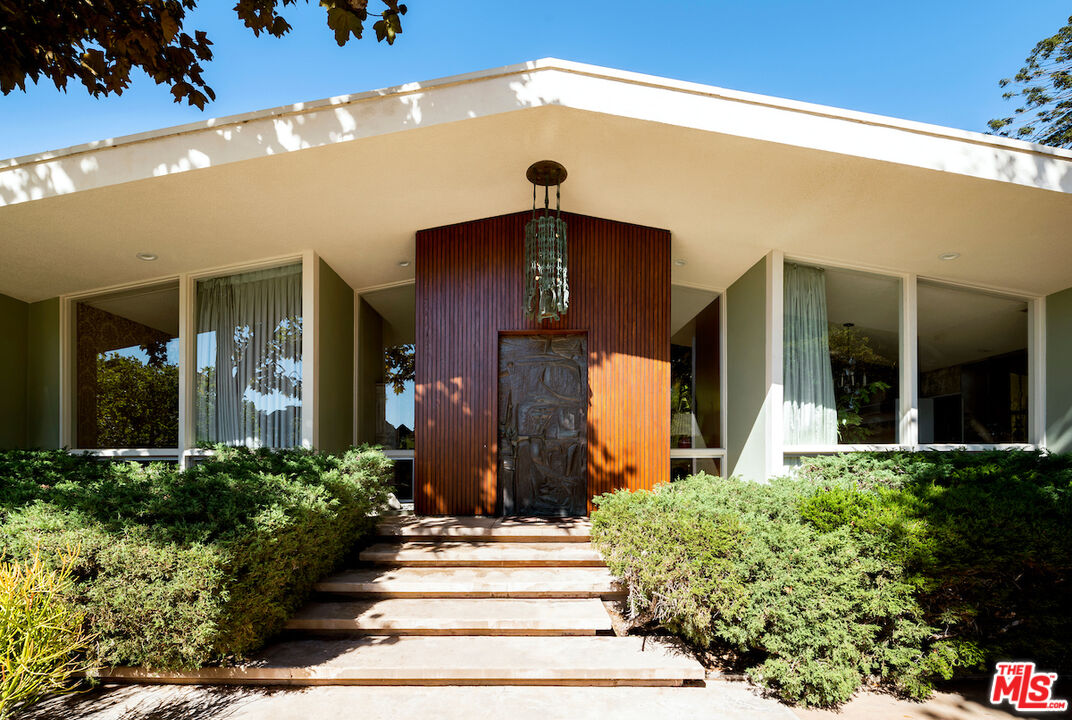 1005 Summit Drive Beverly Hills, CA 90210 - Photo 4 of 48 a front view of a house with a yard