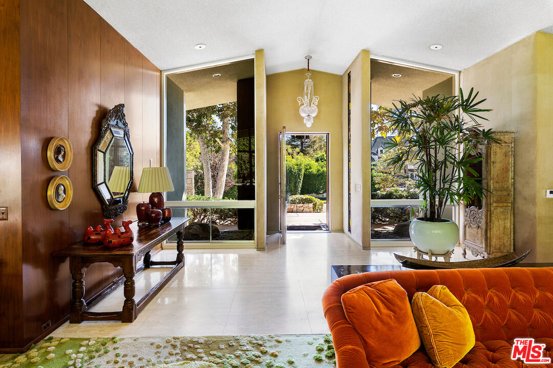 1005 Summit Drive Beverly Hills, CA 90210 - Photo 7 of 48 a living room with patio furniture and a floor to ceiling window