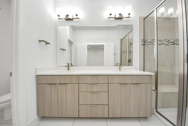 a bathroom with a shower sink and mirror