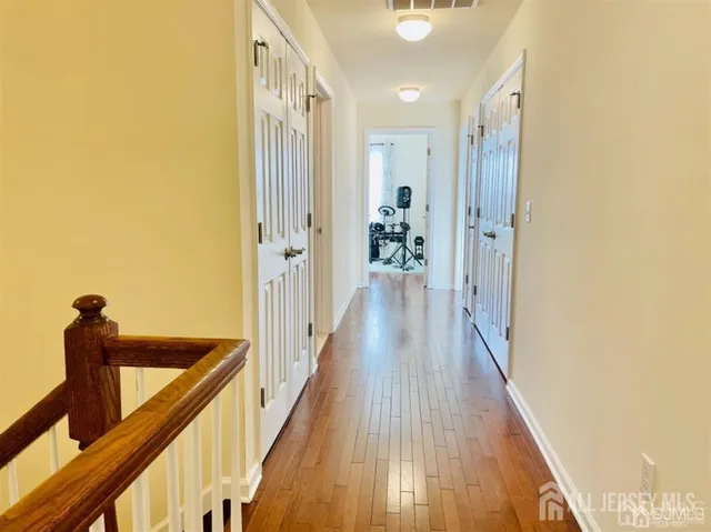 a view of a hallway with wooden floor and staircase