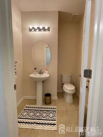 a bathroom with a sink a toilet and a mirror
