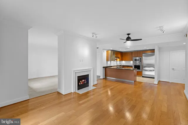 a view of kitchen and empty room with fireplace