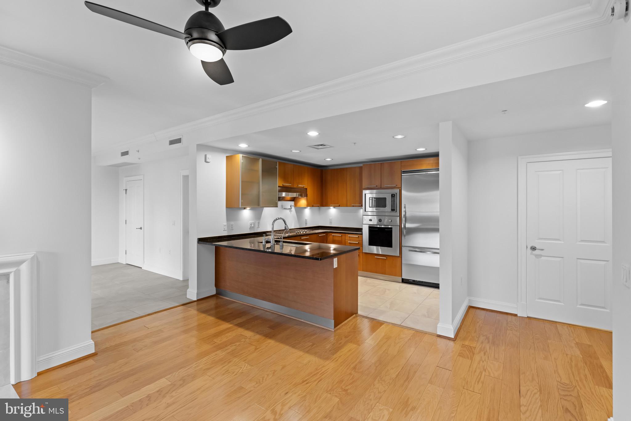 801 Key Highway, Unit 242 Baltimore, MD 21230 - Photo 14 of 52 a large kitchen with stainless steel appliances kitchen island granite countertop a refrigerator and a stove top oven