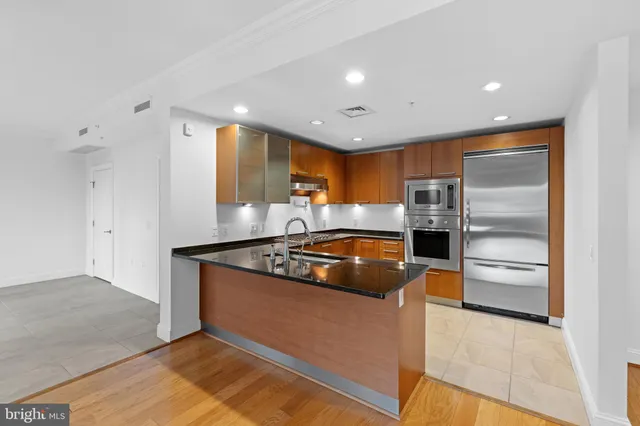 a kitchen with stainless steel appliances granite countertop a stove a refrigerator and a sink