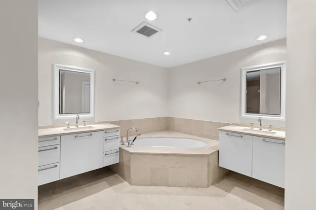 a bathroom with a tub sink and mirror