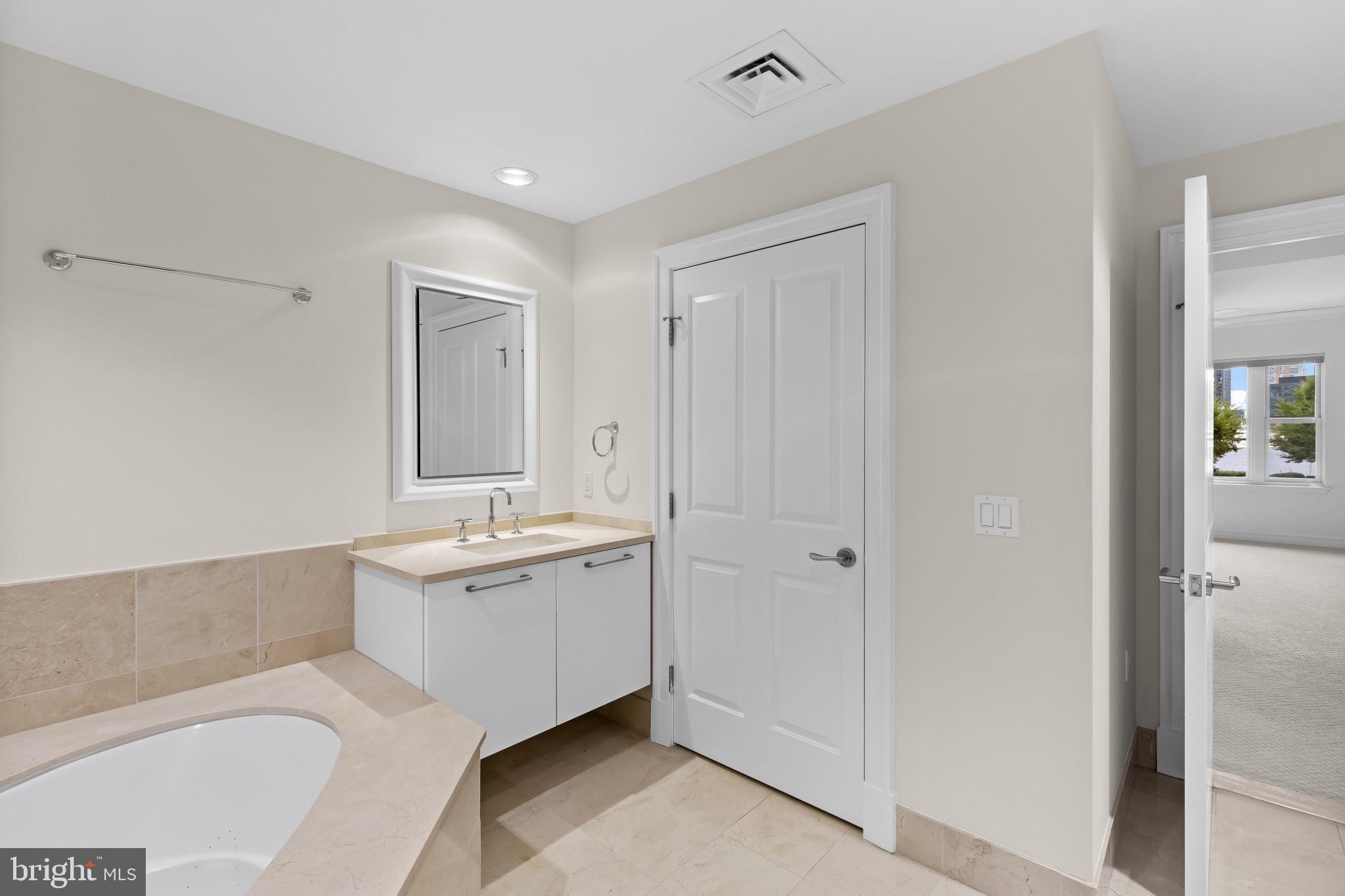 801 Key Highway, Unit 242 Baltimore, MD 21230 - Photo 36 of 52 a bathroom with a tub sink and mirror
