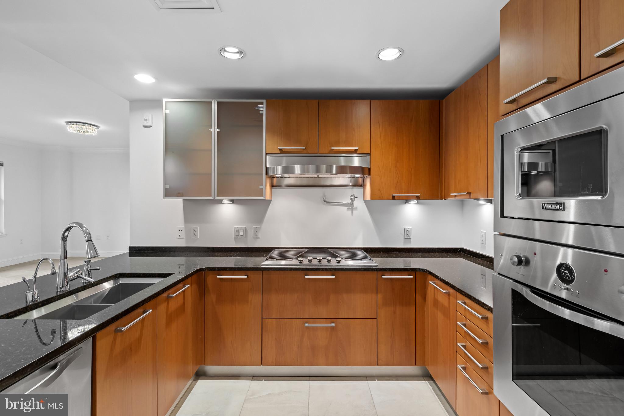 801 Key Highway, Unit 242 Baltimore, MD 21230 - Photo 7 of 52 a kitchen with kitchen island granite countertop a sink stainless steel appliances and cabinets