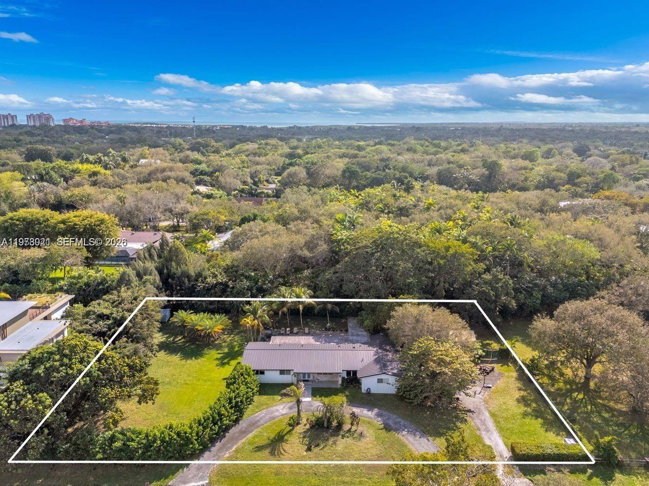 6440 Southwest 129th Terrace Pinecrest, FL 33156 - Photo 2 of 7 a view of a swimming pool with a outdoor seating