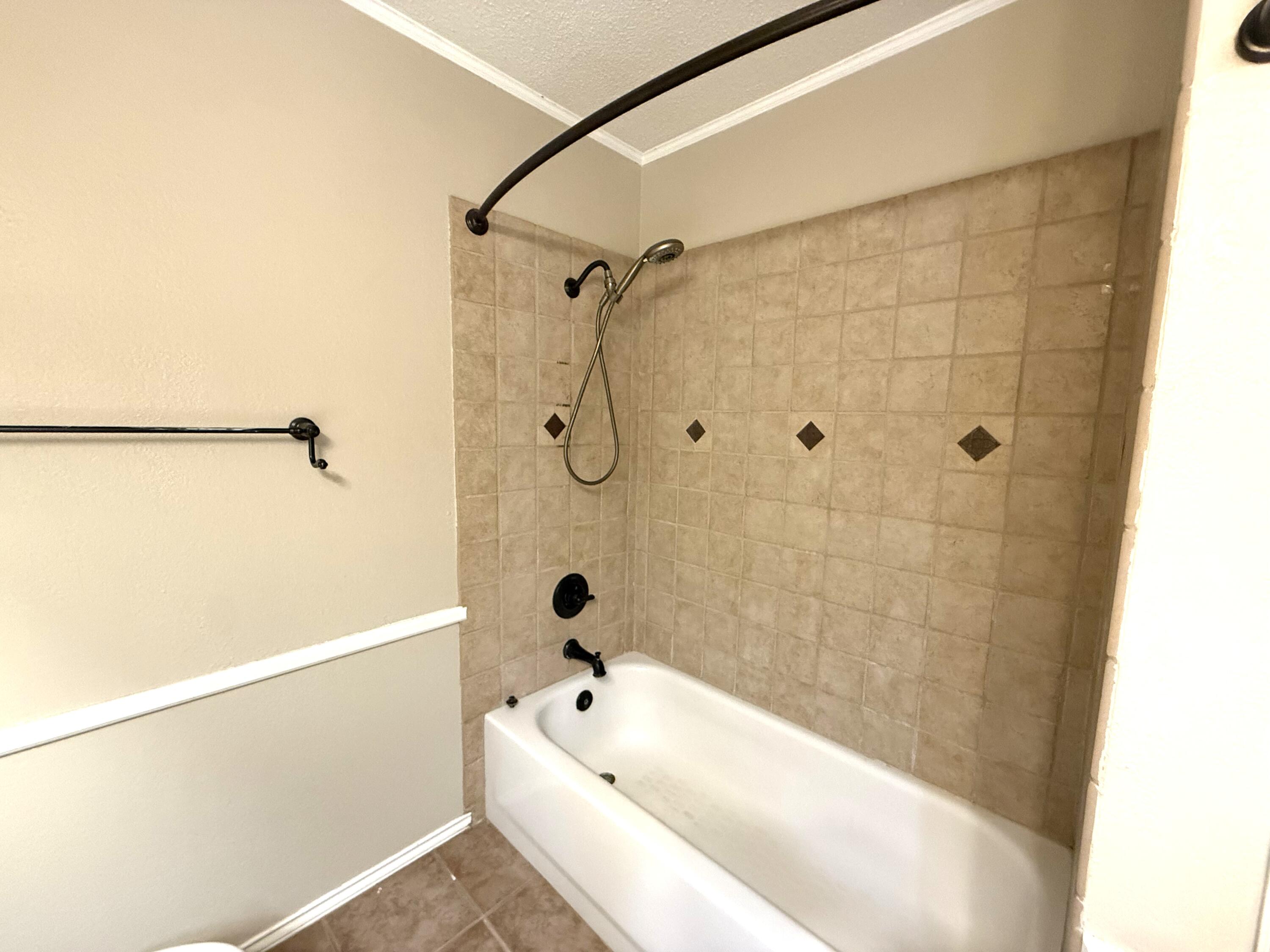 5705 87th Street Lubbock, TX 79424 - Photo 12 of 16 a bathroom with a bathtub and shower