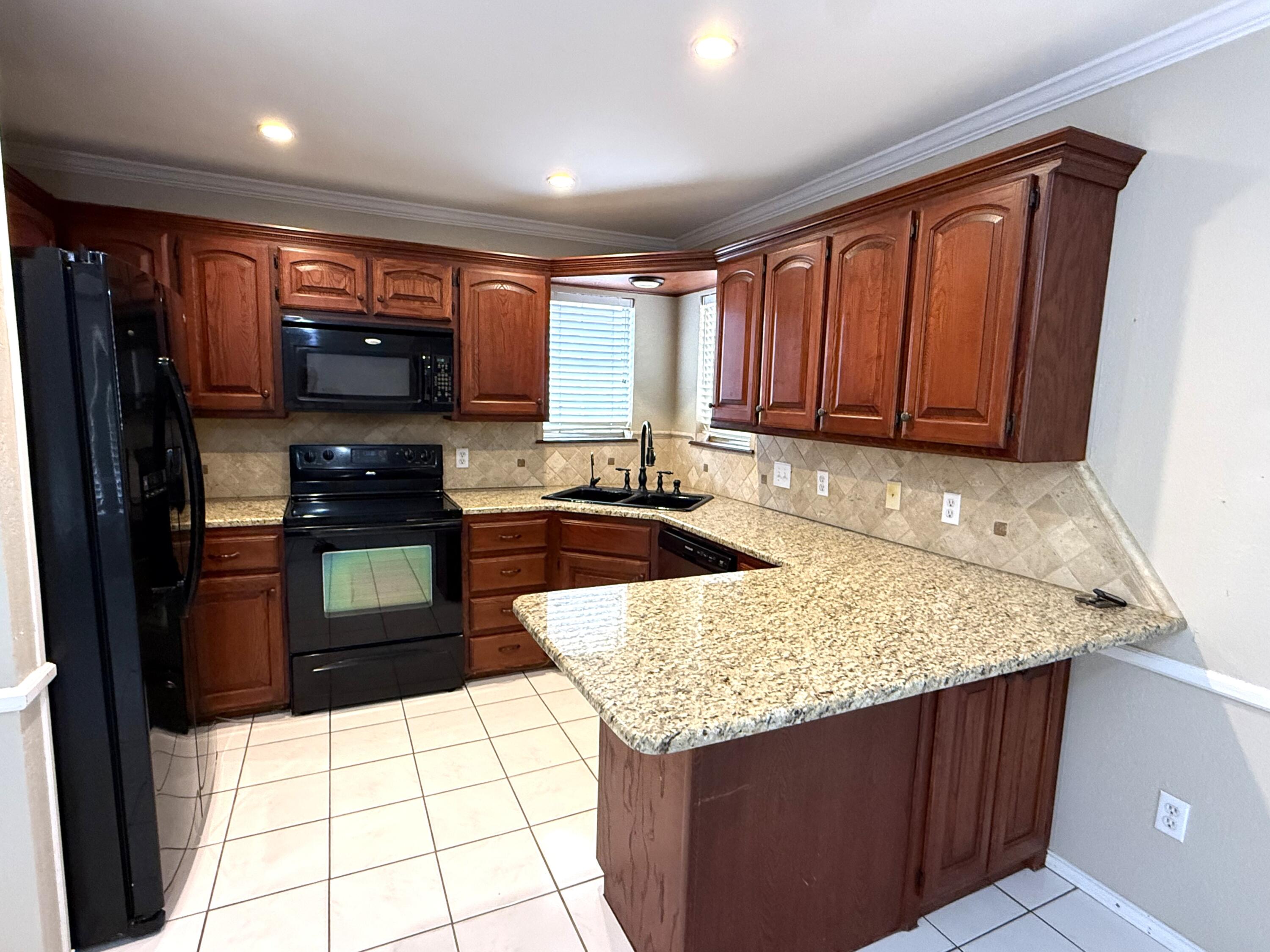 5705 87th Street Lubbock, TX 79424 - Photo 5 of 16 a kitchen with a stove a sink and a refrigerator