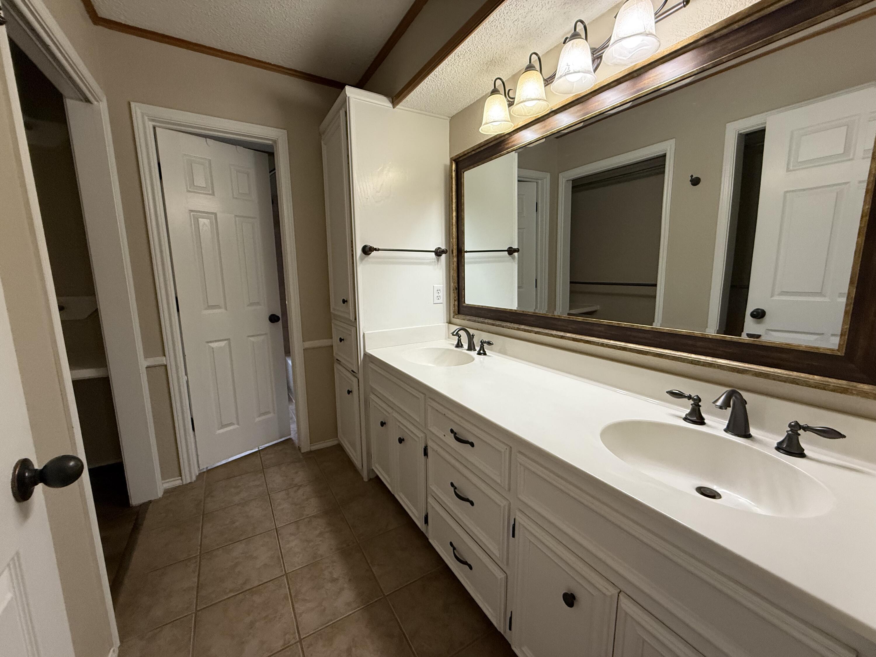 5705 87th Street Lubbock, TX 79424 - Photo 9 of 16 a bathroom with double vanity sink and mirror