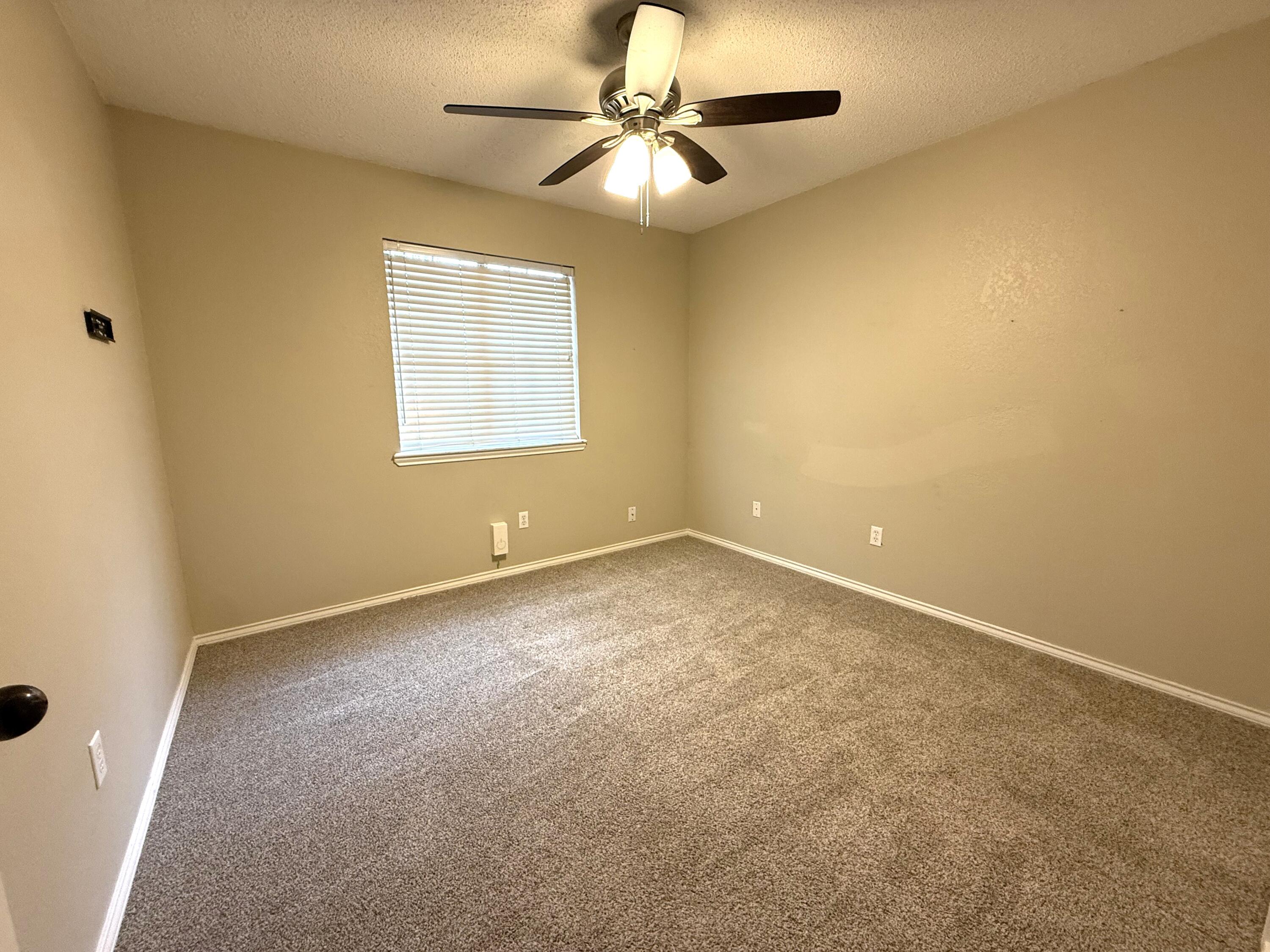 5705 87th Street Lubbock, TX 79424 - Photo 10 of 16 an empty room with a window and a fan