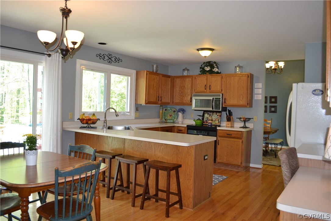 15012 Walnut Bend Road Midlothian, VA 23112 - Photo 4 of 27 a kitchen with stainless steel appliances granite countertop a stove a refrigerator a sink a dining table and chairs with wooden floor
